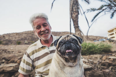 Senior man holding pug