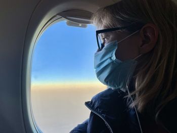 Portrait of woman looking through airplane window