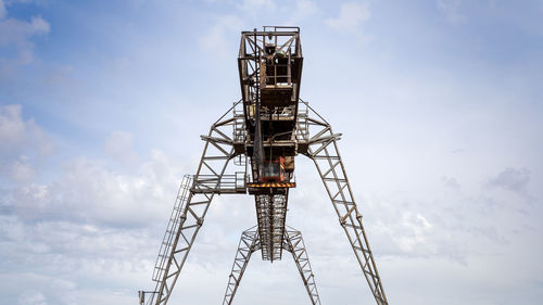 Large metal gantry cranes at a construction site against the blue sky.