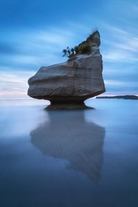 Close-up of rocks in sea against sky