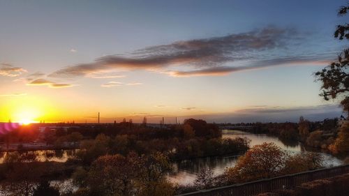 Scenic view of river against sky during sunset