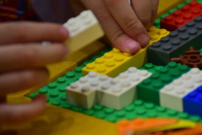 Cropped hands playing with colorful toy blocks