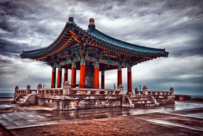 Ancient temple against cloudy sky