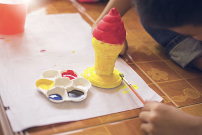 High angle view of hand holding ice cream on table