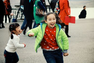 Playful siblings running on road