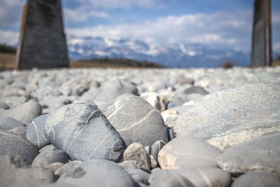 Close-up of pebbles on beach against sky