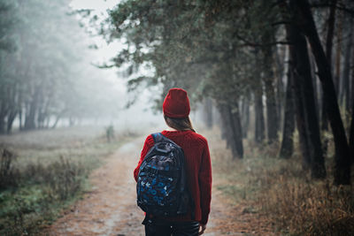 Sustainable tourism, responsible travel. young woman traveler with backpack in pine forest