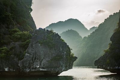 Scenic view of sea by cliff against sky