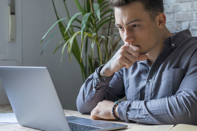 Young man using laptop at home