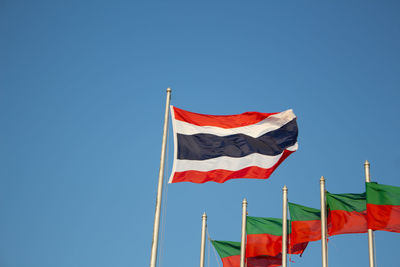 Low angle view of flags flag against clear blue sky