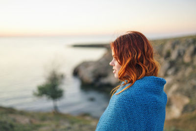 Woman looking at sea against sky