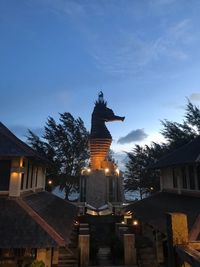 Low angle view of statue against building at dusk