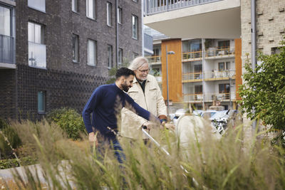 Men talking in front of block of flats