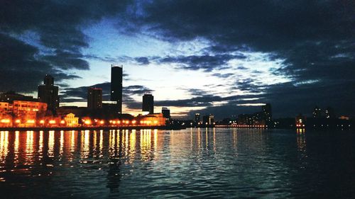 Reflection of illuminated buildings in water at dusk