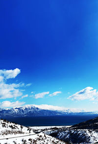 Scenic view of snowcapped mountains against blue sky