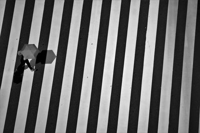 High angle view of person with umbrella crossing road