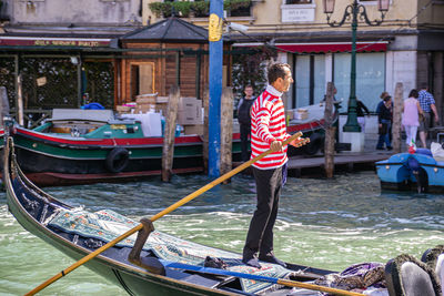 Man standing on boat in canal