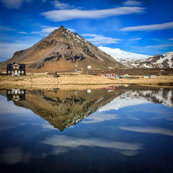 Scenic view of lake and mountains against blue sky