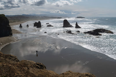 Low tide at bandon beach with one man walking across