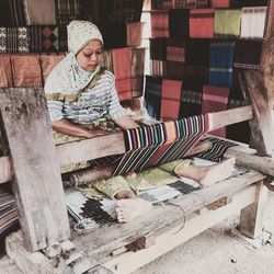 Full length of woman weaving textile