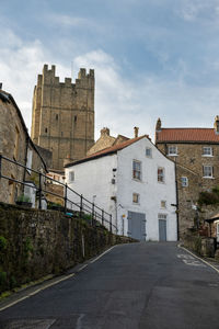 A view looking up along a road of richmond castle with the castle walk and houses in the foreground