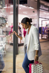 Woman looking in shop window of a fashion store