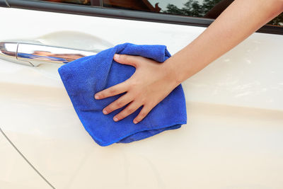 Cropped hand cleaning car with napkin