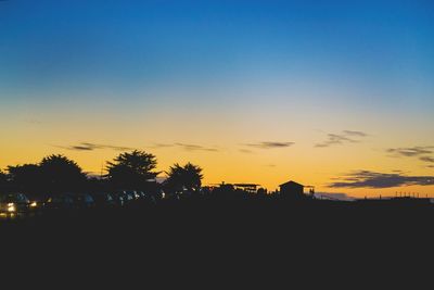 Silhouette landscape against clear sky during sunset