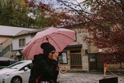 Woman with umbrella against the sky