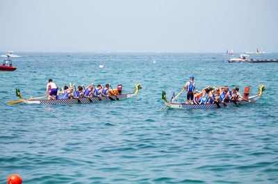 People enjoying in sea against sky