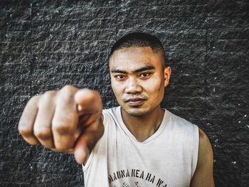 Portrait of man standing against wall