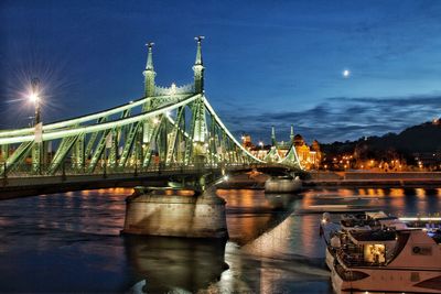 View of bridge over river at night