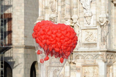 Close-up of red statue against building in city