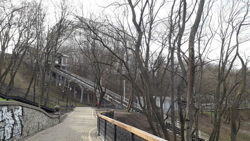 Bridge over canal amidst bare trees during winter