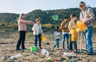 Family collecting garbage at beach