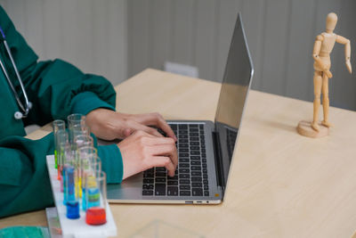 Midsection of man using mobile phone on table