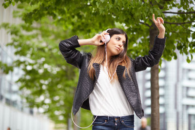 Full length of young woman with arms raised