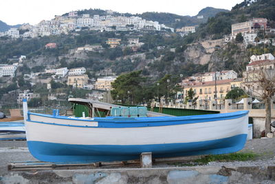 Boats moored on sea by buildings in city