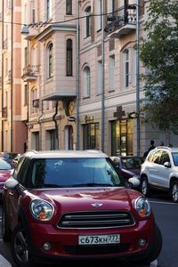 Vintage car on street against buildings in city