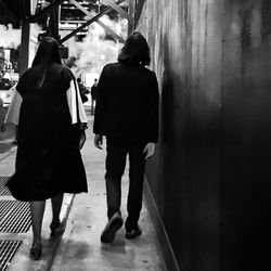 Rear view of couple walking in corridor