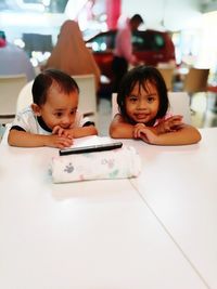 Close-up portrait of smiling girl on table