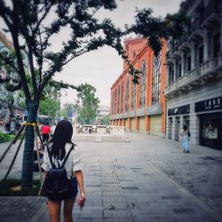 Rear view of woman walking on street in city