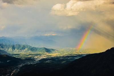 Scenic view of rainbow over mountains against sky