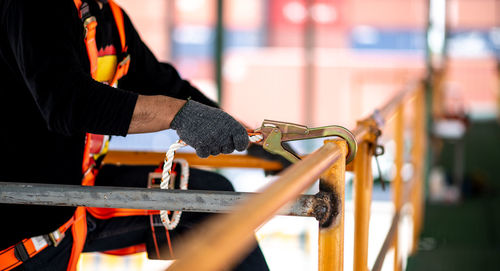 Construction worker wearing safety harness and safety line working at high place