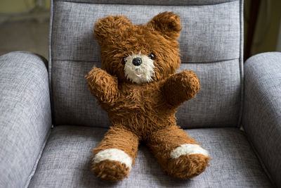 Close-up of teddy bear on armchair