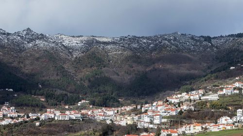 Town by mountain against sky