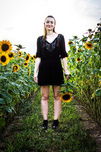 Portrait of beautiful young woman standing on field