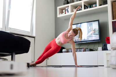 Midsection of woman with arms raised at home