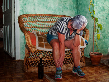 Drunk woman sitting on chair at home