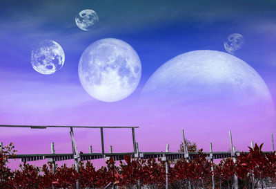 Low angle view of moon against blue sky at night